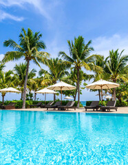 Peaceful tropical swimming pool with crystal-clear turquoise water sparkling under bright midday sun in luxury resort setting
