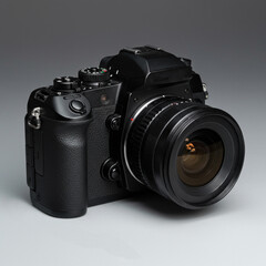 Fototapeta premium High-quality image of a modern DSLR camera with attached lens, isolated on neutral gray background, perfect for tech and product visuals.