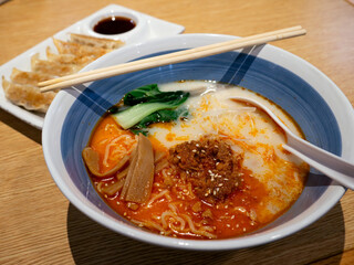 Tan Tan Ramen a spicy tasty Japanese ramen noodle soup and Gyoza a Japanese and Chinese fried dumpling. set on Ramen restaurant table.