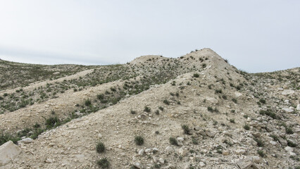 Pokrovsky Cretaceous mountains. Arid landscape features rolling hills covered with sparse vegetation and rocky terrain, showcasing the beauty of nature's rugged formations and textures