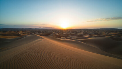 Desert Sunrise with Sand Dunes and Clear Blue Sky