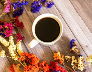 Coffee cup surrounded by dried flowers on a wooden table