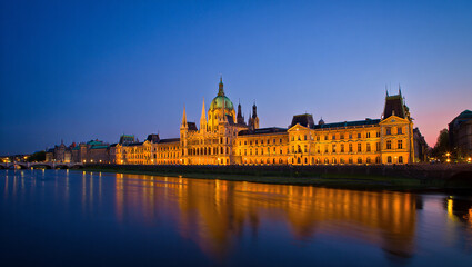 Obraz premium Grand Building on the Riverbank at Dusk