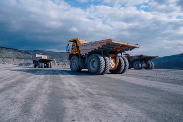 Orange mining truck against background of the slopes of an asbes