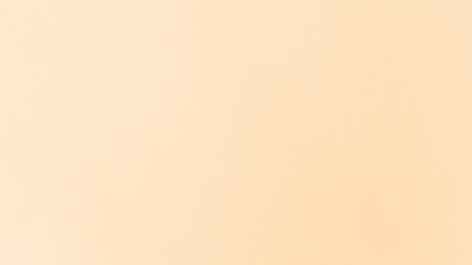 Soft peach hues flow like a calm morning sun, warming the cement wall with a glow of understated charm.