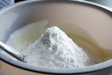 Powdered or icing sugar in plastic bowl.