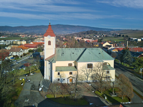 Aerial view of St. Francis of Assisi Church stands majestically with its red-tipped spire, contrasting against the clear blue sky, Detva, Bansk&Atilde;&iexcl; Bystrica Region, Slovakia.