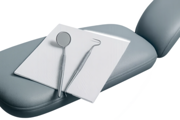 Dental mirror and hook placed on tissue on dental chair in clinic setting