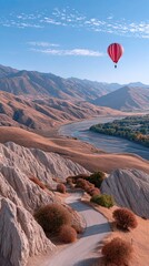 Fototapeta premium Red Hot Air Balloon Soaring Over a Mountain Valley