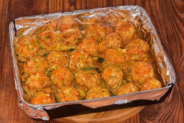 Rice meatballs stewed with red sauce in deep baking tray