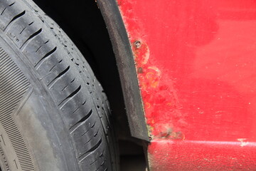 rust, bubbles, corrosion and paint damage on the car fender of a red suv © Willy Matheisl