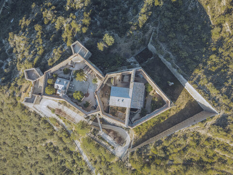 Aerial view of the imposing Liberia Fort, standing with its stone walls amidst the verdant embrace of nature, Liberia Fort, Occitanie, France.