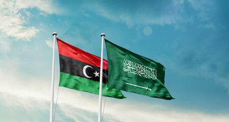 Libya and Saudi Arabia friendship flags are waving in the sky. Two country flag for agreement or...