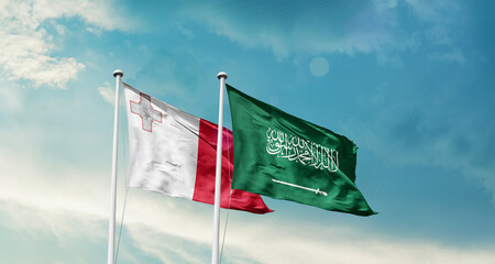 Malta and Saudi Arabia friendship flags are waving in the sky. Two country flag for agreement or deal. Malta KSA national flag for commitment.