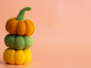 Knitted orange pumpkins on an orange background, autumn composition, front view, Halloween concept