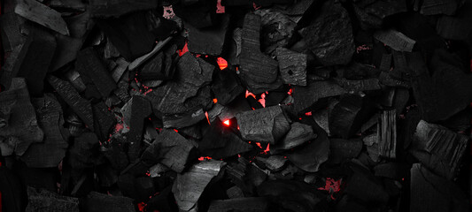 Black charcoal texture. Glowing hot charcoal for barbecue. Top view. Free space for text.