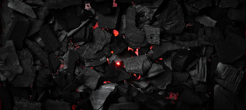 Black charcoal texture. Glowing hot charcoal for barbecue. Top view. Free space for text.