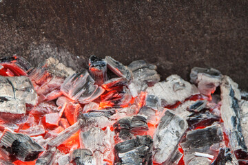 Photo of hot coals. texture of coals on the grill. Edge in the grill