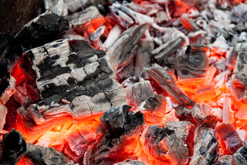 Photo of hot coals. texture of coals on the grill. Edge in the grill