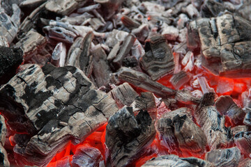 Photo of hot coals. texture of coals on the grill. Edge in the grill