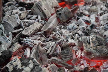 Photo of hot coals. texture of coals on the grill. Edge in the grill