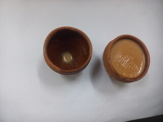 This photo shows a traditional kulhad (clay cup) filled with chai (Indian tea).These clay cups are commonly used to serve hot tea in India, especially at roadside tea shops. Kulhad chai has a distinc