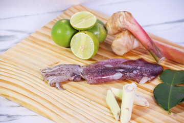 Whole Squid with Tom Yum Ingredients on Wooden Cutting Board