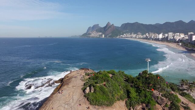 Aerial drone shot of Ipanema Beach and Pedra do Arpoador on a sunny day in Rio de Janeiro, Brazil.	
