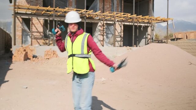 At a construction site, a slacker in a hard hat and vest dances wildly with a drill, swinging his arms to the music. Filled with carefree energy, he turns a quick break into a noisy distraction.