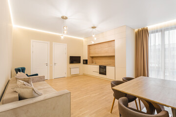 Modern living room and kitchen area with bright natural light and contemporary design features