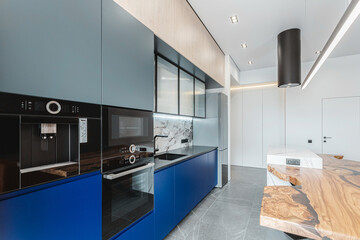 Modern kitchen design featuring sleek blue cabinets and elegant marble countertops in a contemporary home