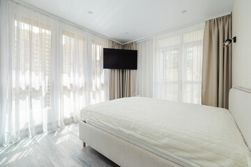 Modern bedroom with natural light and minimalist decor in urban apartment setting