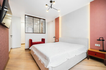 Modern bedroom interior design featuring a cozy bed and stylish decor in a bright, inviting space