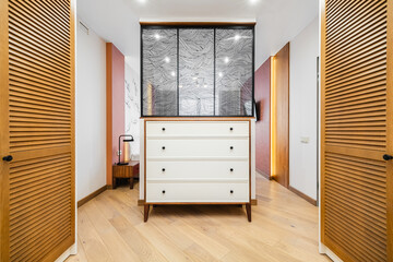 Modern dresser with wood accents and textured glass in a stylish interior hallway