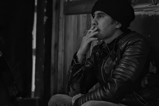 Hombre joven fumando un cigarrillo. hombre con expresi&oacute;n triste, adicci&oacute;n al cigarrillo.