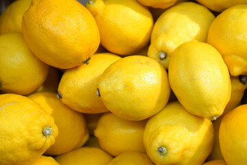 Large heap of ripe yellow lemons in a fruit and vegetable store display