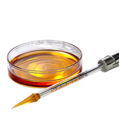 Clear petri dish filled with amber liquid and a measuring pipette