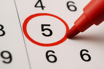 A macro shot of a calendar page with a red circle drawn around the number five, highlighting it.