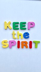 Colorful wooden letters spelling out "Keep the Spirit" on a white background.