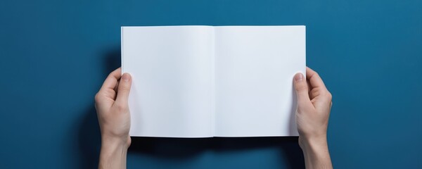 Hands hold blank white booklet spread open. Clean paper pages, space for text, designs, layout, advertising. Presentation, marketing, corporate branding template. Education, manual, guide poster,