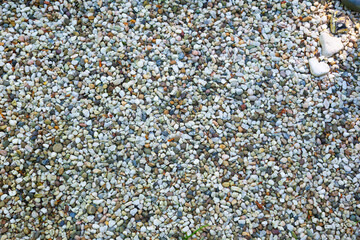 Aluminum decorative hearts lie on stone pebbles.