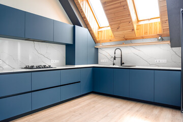 Blue minimal kitchen. Attic skylights. Bright marble