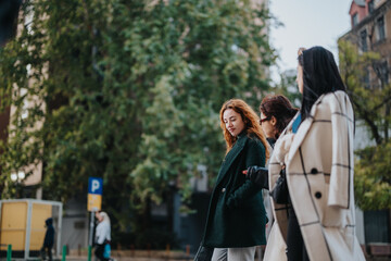 Three women enjoying their day outdoors, walking together in a leafy city area during mild weather conditions, fostering a cheerful and friendly atmosphere.