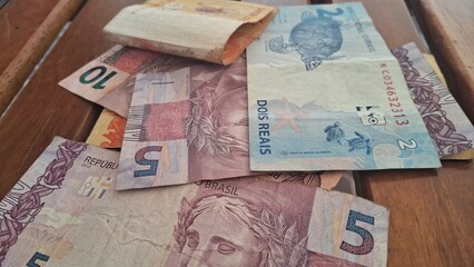 Brazilian real notes superimposed on a wooden background
