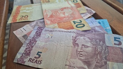 Brazilian real notes superimposed on a wooden background