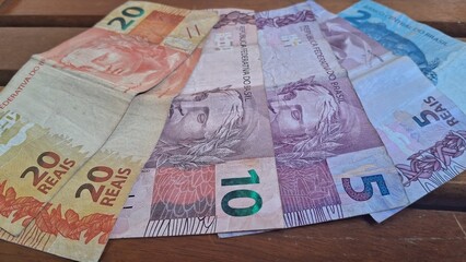 Brazilian real notes superimposed on a wooden background