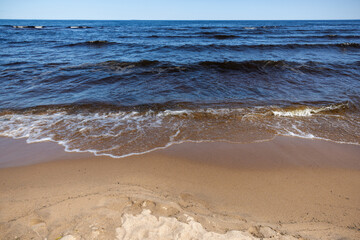 Coastal landscape with sandy ground and shore waves of Lake Ladoga