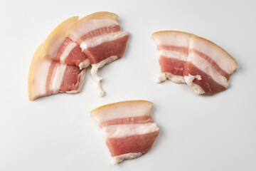 Raw bacon isolated on white background. Close-up of sliced raw pork bacon