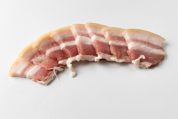 Raw bacon isolated on white background. Close-up of sliced raw pork bacon