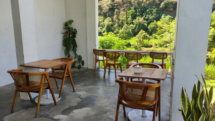 Photo of a dining table with green color combined with wood made of iron in the outer side of the restaurant and specifically for outdoor dining tables.